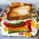 Terrine tricolore aux 3 poivrons coupée en tranche montrant les couches jaunes, vertes et rouges
